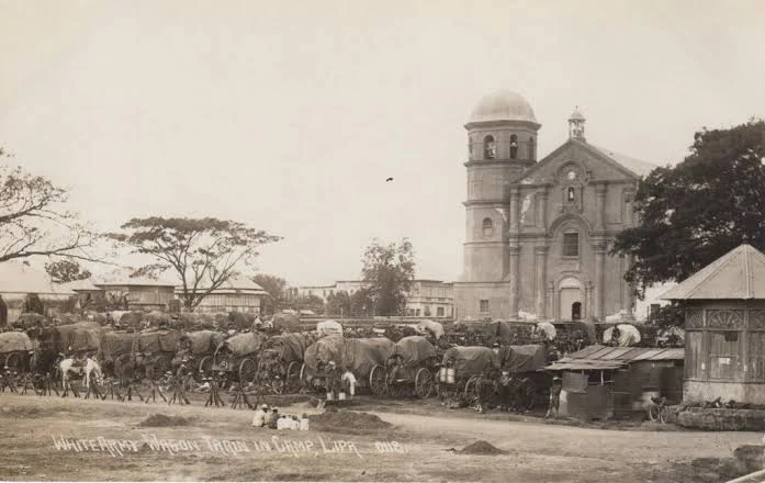 An American army wagon train camped before the church at Lipa, 1901